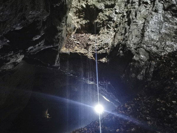 A bright ray of light falls into a dark and mysterious cave, High Tatras, Poland