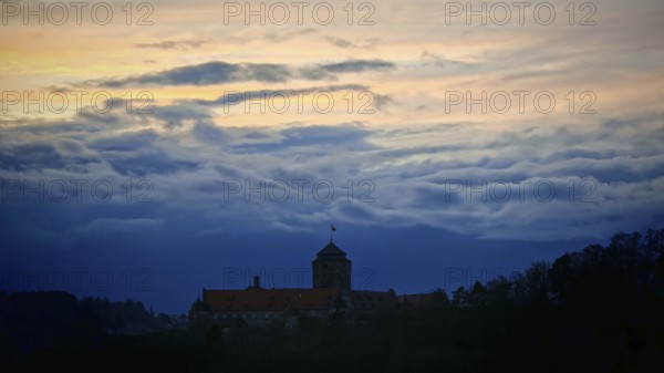 Castle silhouette against dramatic sunset sky, calm and mystical atmosphere, Rosenberg Fortress, Franconian Forest