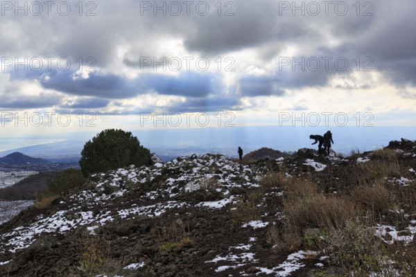 Barren volcanic landscape with remnants of snow, hikers, Etna, Etna, Catania, Sicily, Italy