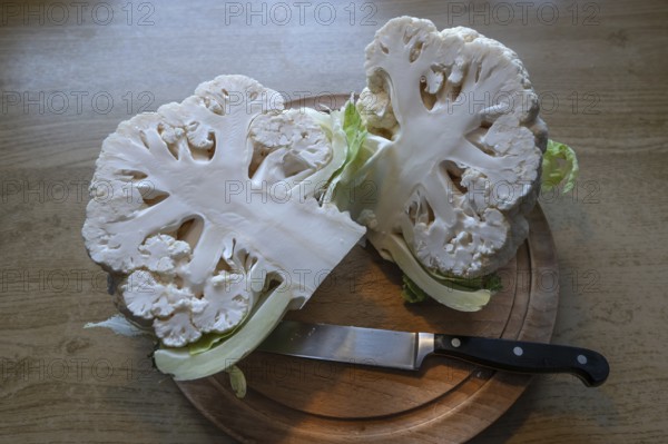 Halved cauliflower (Brassica oleracea var. botrytis) on a wooden board, Bavaria, Germany