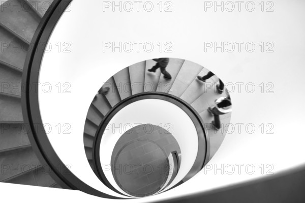 Spiral staircase with descending persons, black and white, Bavaria, Germany