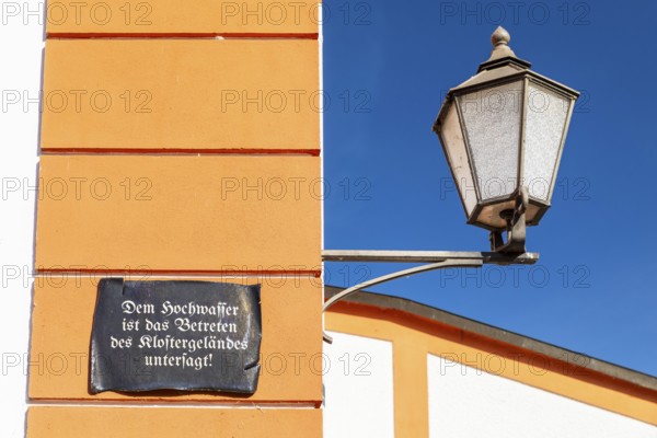 Lantern and façade with sign, Floods are prohibited from entering the monastery grounds, St. Marienthal Abbey, Ostritz, Saxony, Germany