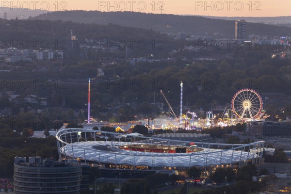29 Sep 2018 at dusk, Volksfest lights seen from Rotenberg chapel with stadium foreground and Pragsattel background. Stuttgart, Baden-Wurttemberg, Germany