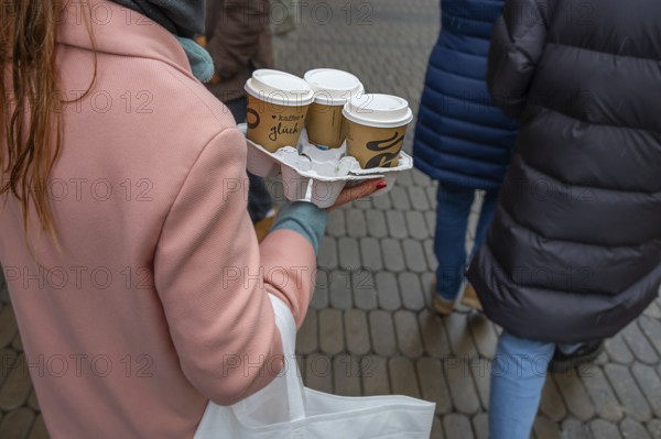 Lady carrying three coffees to go on the street, Nuremberg, Middle Franconia, Bavaria, Germany