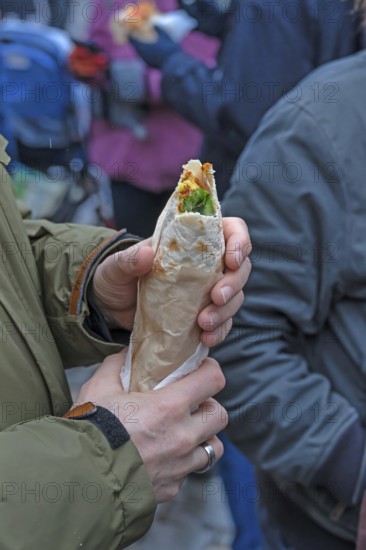 Hands holding a fresh falafel with vegetables, Nuremberg, Middle Franconia, Bavaria, Germany