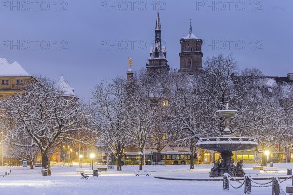 Winter in Stuttgart. The city is wintry white early in the morning. Castle square with fountain and collegiate church. Stuttgart, Baden-Württemberg, Germany