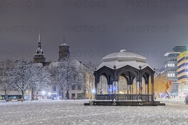 Winter in Stuttgart. The city is wintry white early in the morning. Palace Square with bandstand and collegiate church. Stuttgart, Baden-Württemberg, Germany