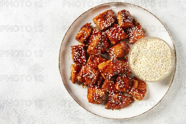 Fried pieces of salmon teriyaki with sesame seeds, top view
