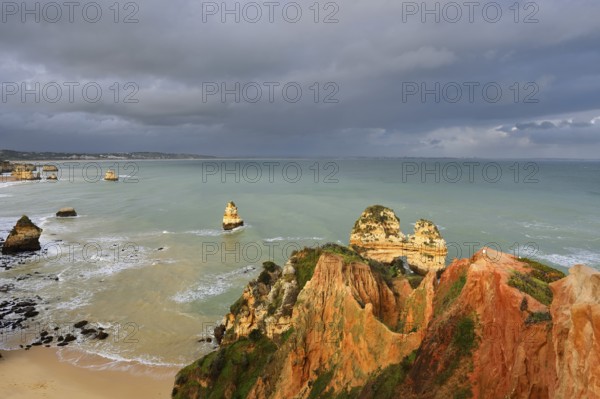 Rocky coast with storm cloud, Praia do Camilo, Lagos, Algarve, Portugal