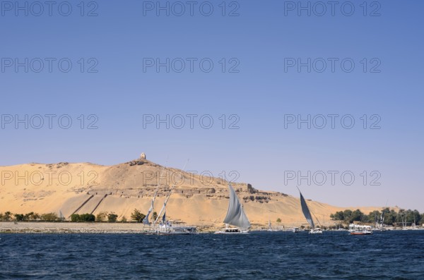 Qubbet el-Hawa with the rock tombs on the Nile, Aswan, Egypt