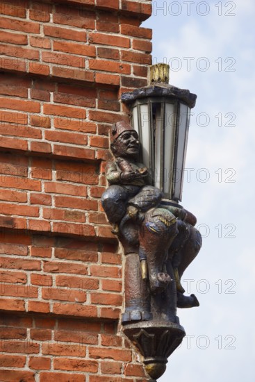 Lantern and sculpture on a house wall, Plön, Holsteinische Schweiz nature park Park, Schleswig-Holstein, Germany