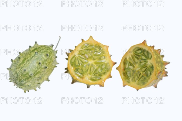 Horned cucumber, kiwano or horned melon (Cucumis metuliferus), whole and sliced fruit on a white background, native to Africa