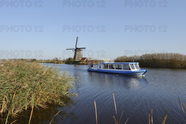 Historic windmill and sightseeing boat, UNESCO World Heritage Site, Kinderdijk, South Holland, Netherlands