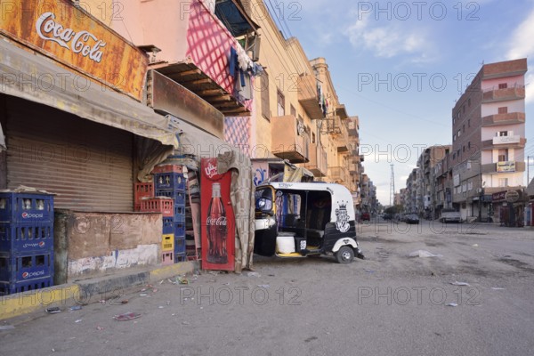 Street and a parked tuk-tuk in front of a shop, Esna, Egypt