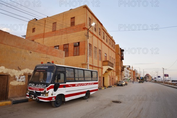 Bus parked on a street and houses, Esna, Egypt