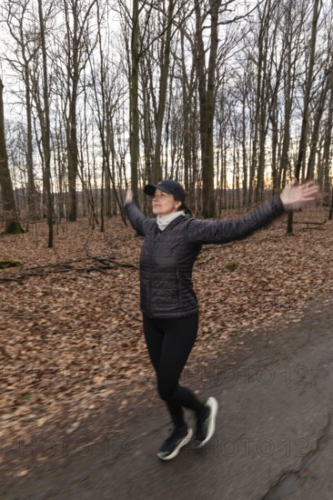 Woman jogging and doing sport exercise in winter nature. Germany