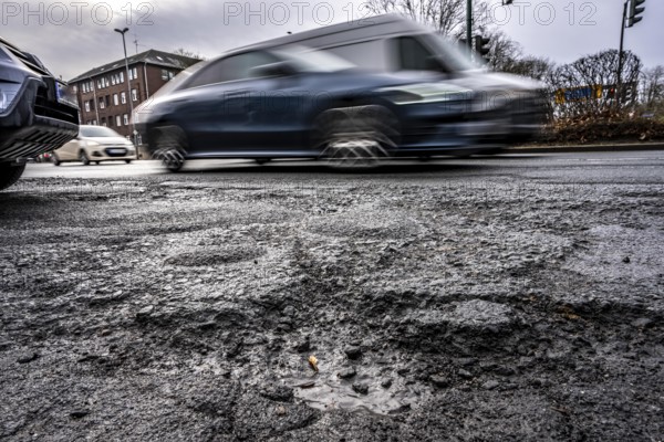 Large potholes at the confluence of Kruppstraße with Friedrichstraße, B224, heavy vehicle traffic, cars and trucks, as well as winter weather conditions have severely added to the road surface, Essen, North Rhine-Westphalia, Germany