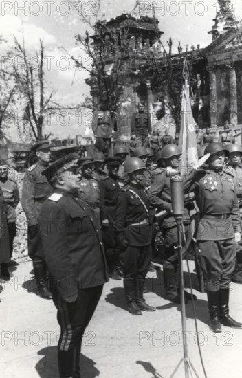 Soviet soldiers salute the destroyed Reichstag in Berlin, Germany, June 1945
