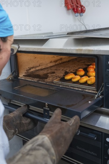 A baker takes freshly baked rolls out of a hot oven, bake rolls, Haselstaller Hof, Gechingen, Germany