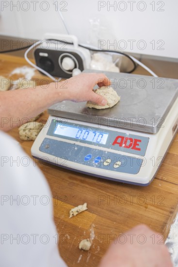 A hand weighs a piece of dough on a digital kitchen scale, bake rolls, Haselstaller Hof, Gechingen, Germany