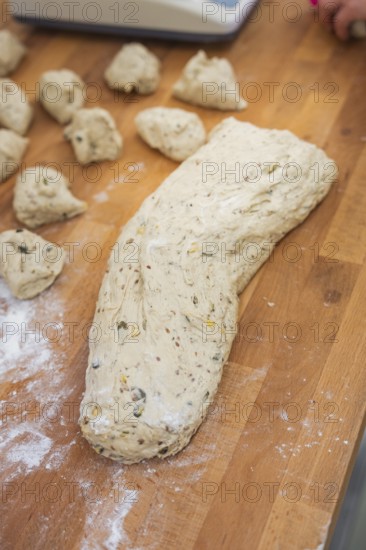 A large lump of dough and small pieces of dough on a floured wooden table, baking rolls, Haselstaller Hof, Gechingen, Germany