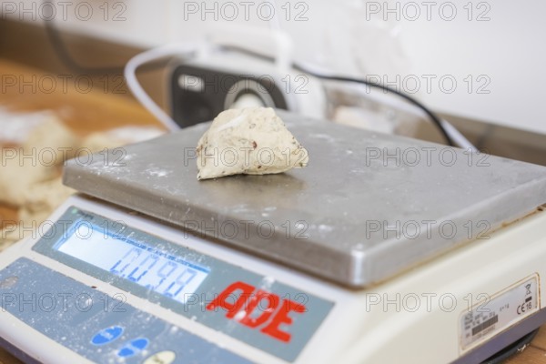 A piece of dough is measured on a digital scale in a bakery, bake rolls, Haselstaller Hof, Gechingen, Germany