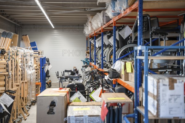 Storage room with shelves full of wheelchairs and boxes, industrial and organized, medical supply store