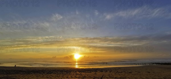 A calm sunset on the beach with cloudy sky and gentle sea, Sidi Ifni, Morocco