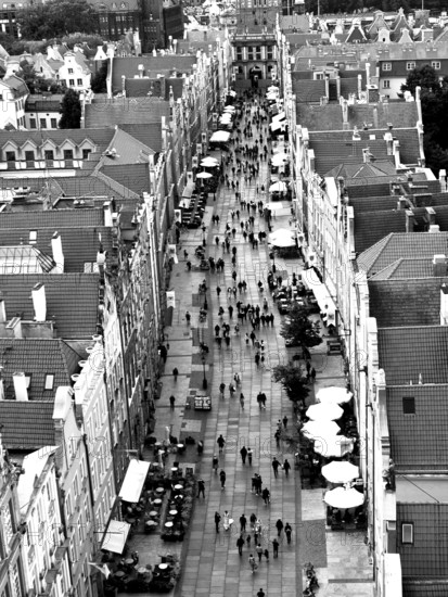 Aerial view of a busy urban street lined with historic buildings in black and white, view from St. Mary's Church over old town of Gdansk, Poland
