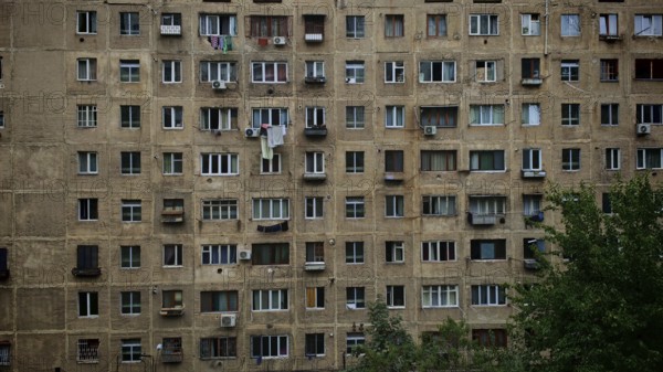 An old apartment block with lots of windows and balconies, surrounded by trees, Tbilisi, Georgia