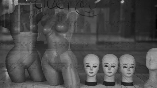 Shop window with mannequins and heads in a melancholy black and white atmosphere, Skopje, Macedonia