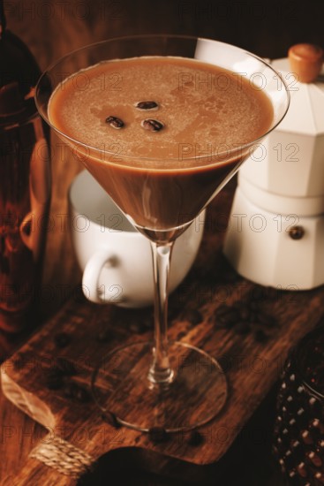 Espresso martini cocktail, alcoholic drink, shaker and geyser coffee maker, on a wooden background