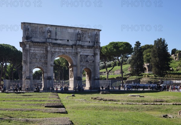 Arch of Constantine with tourists on sunny day, Lazio, Italy