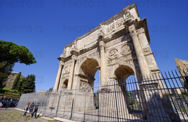 Arch of Constantine with detailed reliefs under blue sky, Rome, Lazio, Italy