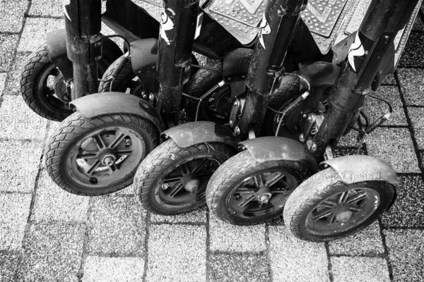 Black and white view of lined up, parked e-scooters on a paved surface, Singen am Hohentwiel, Hegau, Konstanz district, Baden-Württemberg, Germany
