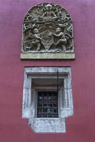 Relief with coat of arms and angels on a coloured house wall, Krakow, Poland
