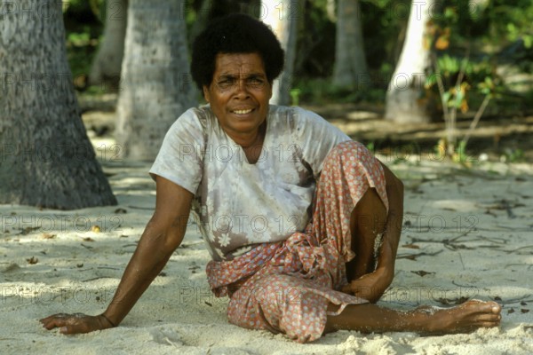 Woman sitting in the sand (there are no chairs on Tavewa) Tavewa Island, Yasawa Islands, Fiji