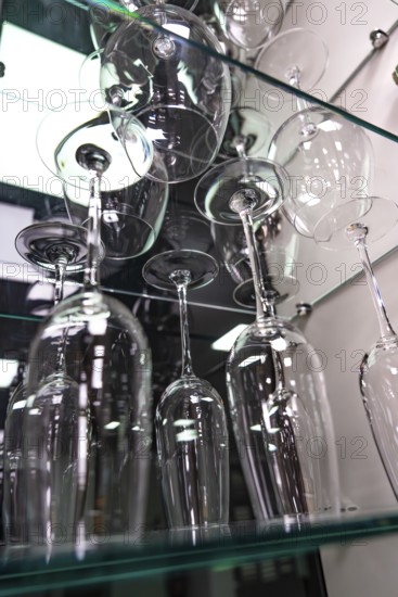 Showcase with elegant wine glasses on glass shelves