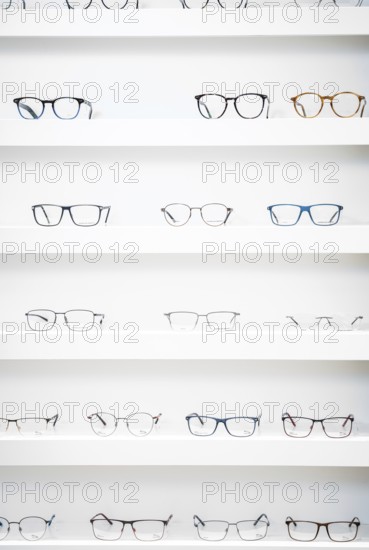 Several pairs of glasses neatly arranged on shelves in an optician's shop, optician, Pforzheim