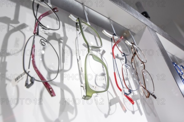 Different colorful glasses hanging on a shelf in a modern way, optician, Pforzheim