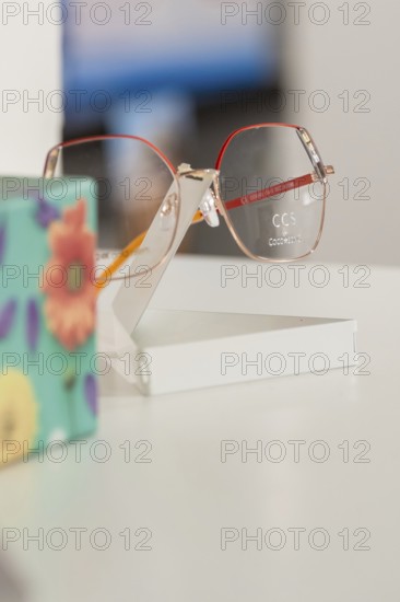 Close-up of stylish glasses next to a colorful floral pattern, optician, Pforzheim