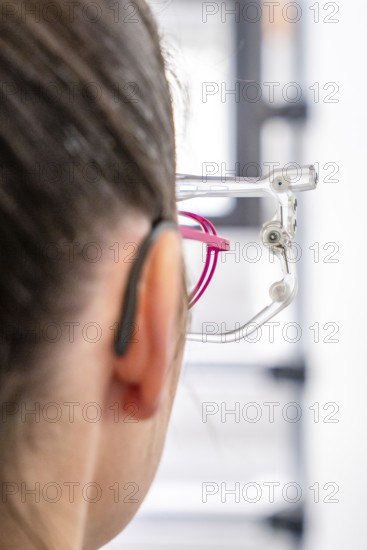 Woman wearing a hearing aid and glasses, close-up in an optical environment, optician, Pforzheim