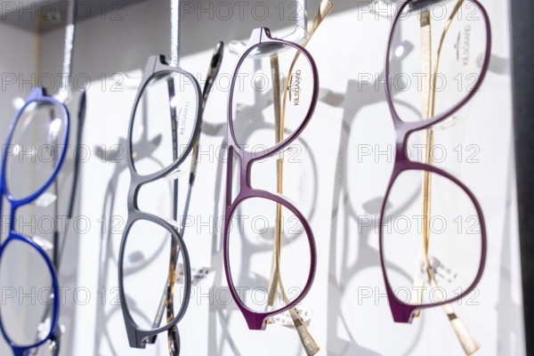 Colourful glasses in various modern designs on a hanger, optician, Pforzheim