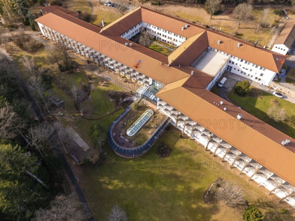A building complex with a red roof and a spacious courtyard with green space from a bird's eye view, Rehab Clinic, Schömberg, Black Forest, Germany