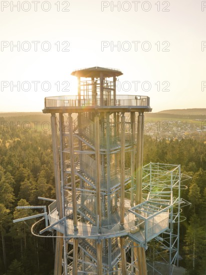 Sunbeams from an observation tower standing over a dense forest shine through the metal structure, Himmelsglück observation tower with Flying Fox, Schömberg, Black Forest, Germany