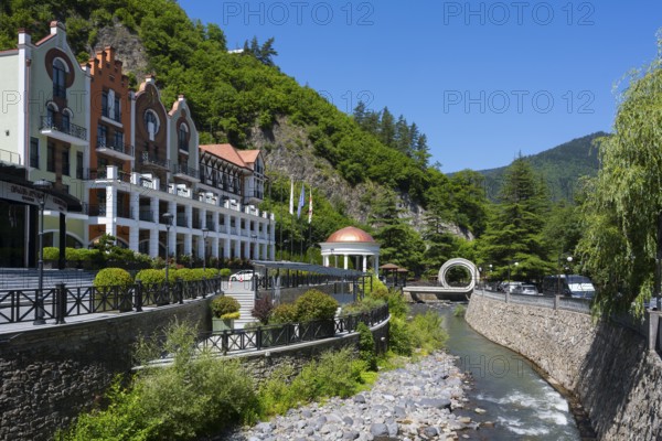 Hotel on a river surrounded by green mountains and vegetation in sunny weather, Hotel Crowne Plaza Borjomi, Borjomi, Borjomula River, Samtskhe-Javakheti Region, Lesser Caucasus, Georgia