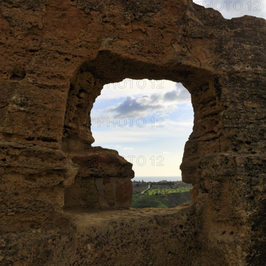 Arkosolium path, necropolis, view through arched niche on coastline and the sea, burial chamber, carved into the rock, wall, Valley of the Temples, Agrigento, Sicily, Italy