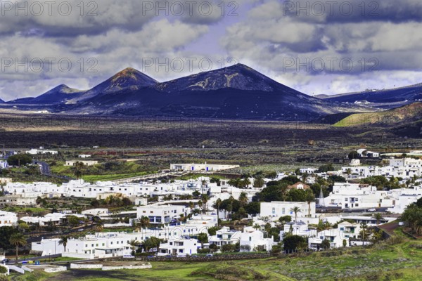The municipality of Yaiza with white houses in a volcanic mountain landscape and cloudy sky, Yaiza Lanzarote