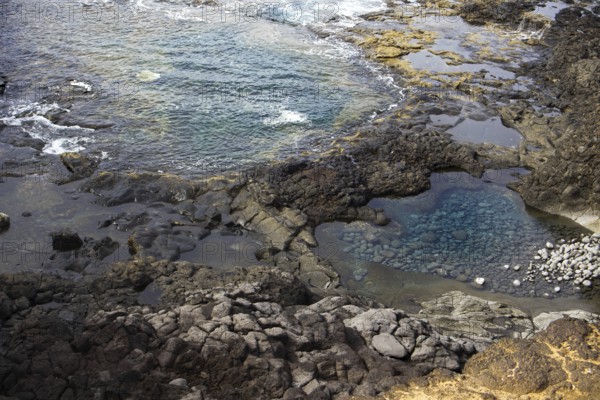 Rocky landscape with cliffs and natural pools with clear water on a rough, wave-driven coast, Yaiza Lanzarote