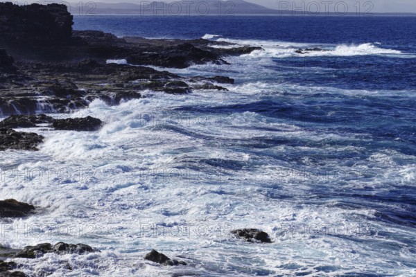 Thundering waves meet rocky coast under a cloudy sky, Yaiza Lanzarote
